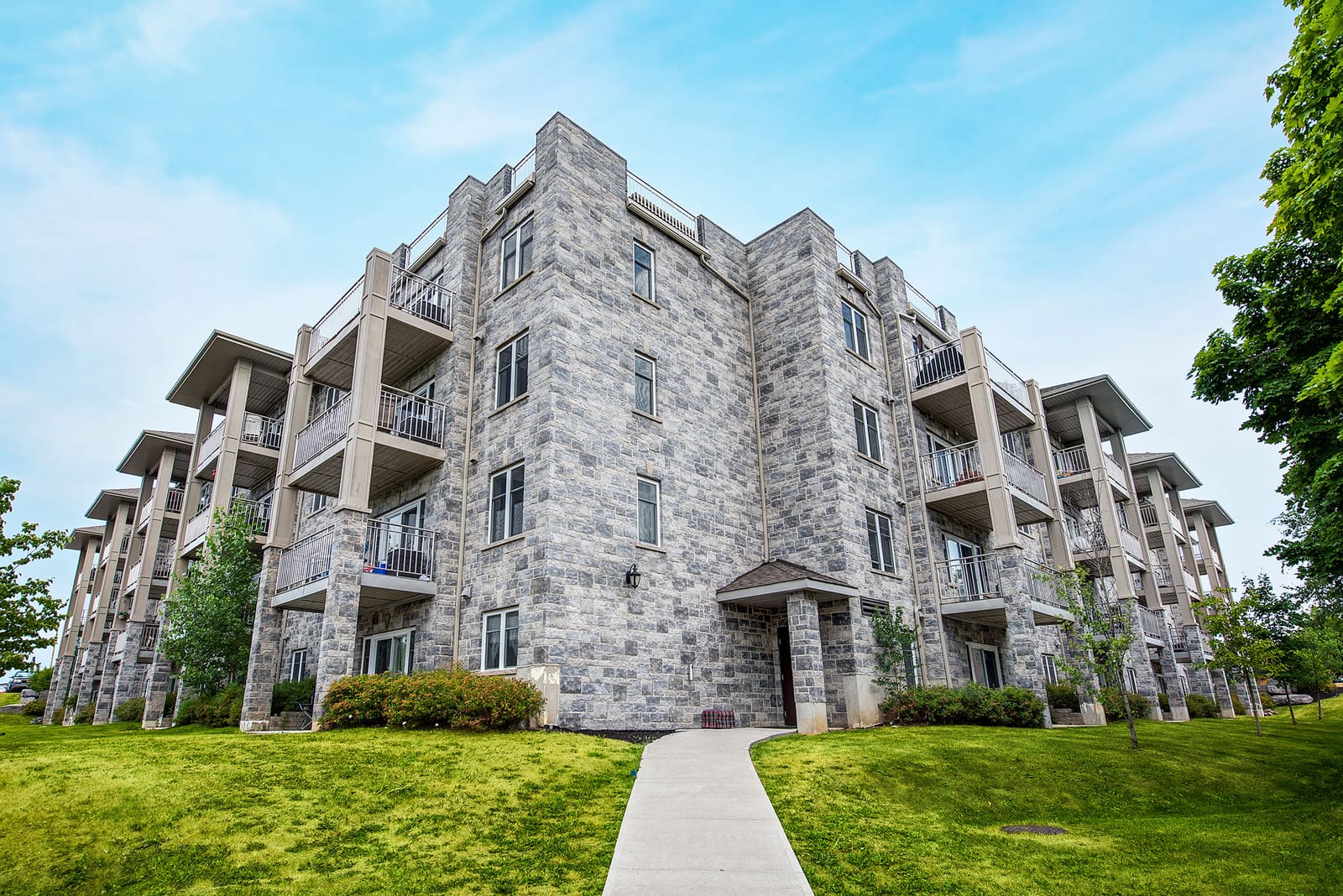 Stone corner of the building and its stacked balconies, seen from the lawn