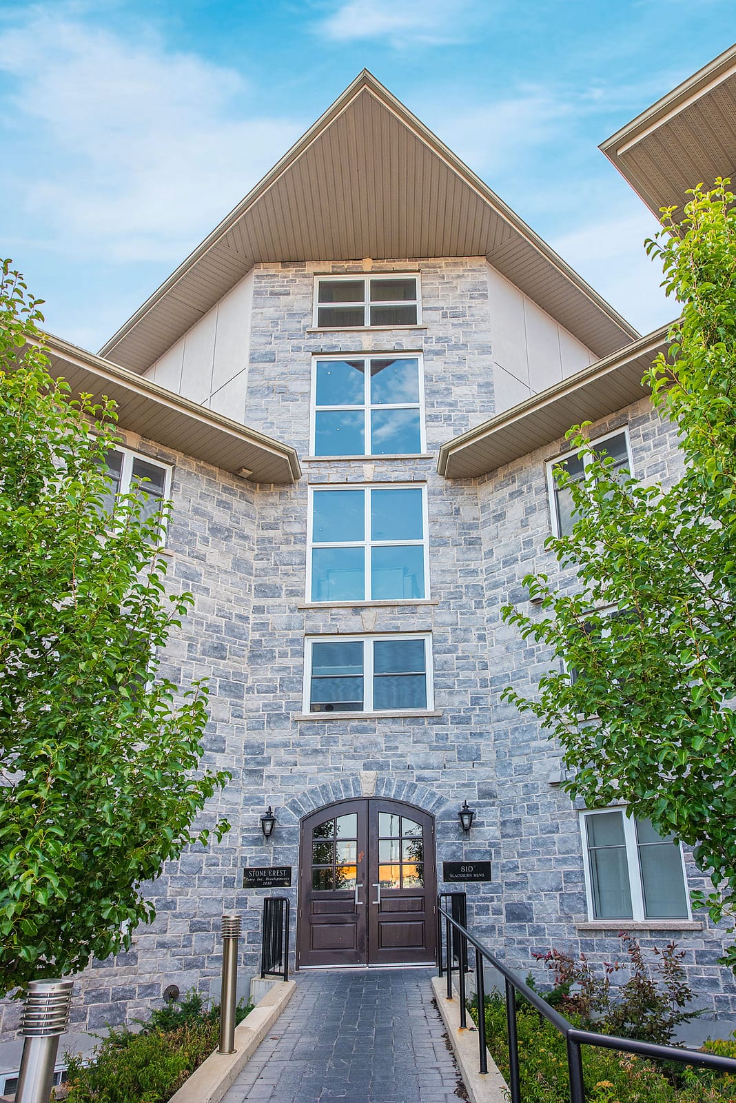 Front entrance at 810 Blackburn Mews, with the arched double doors under the stone gable