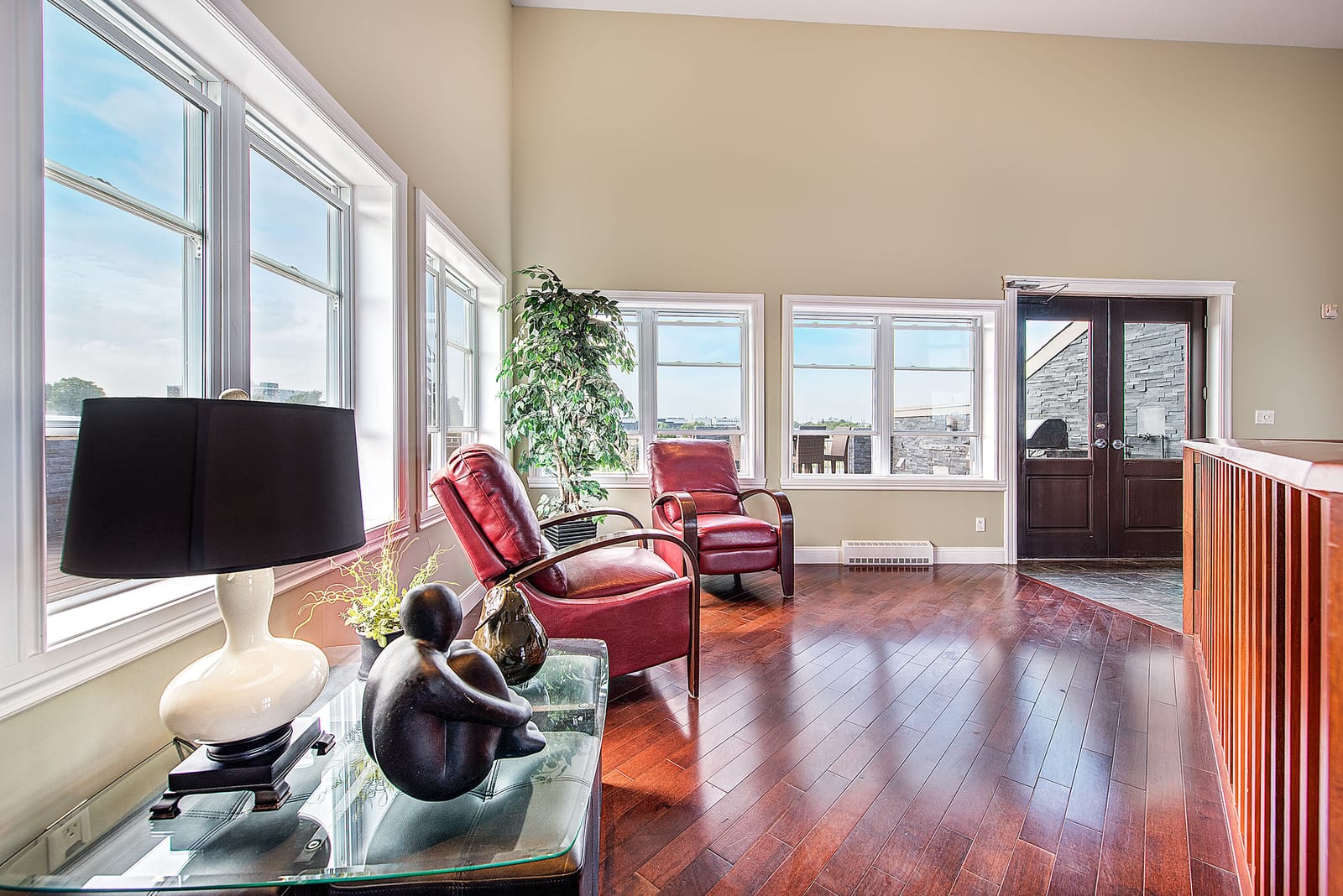 Mezzanine lounge above the party room, with armchairs and tall windows