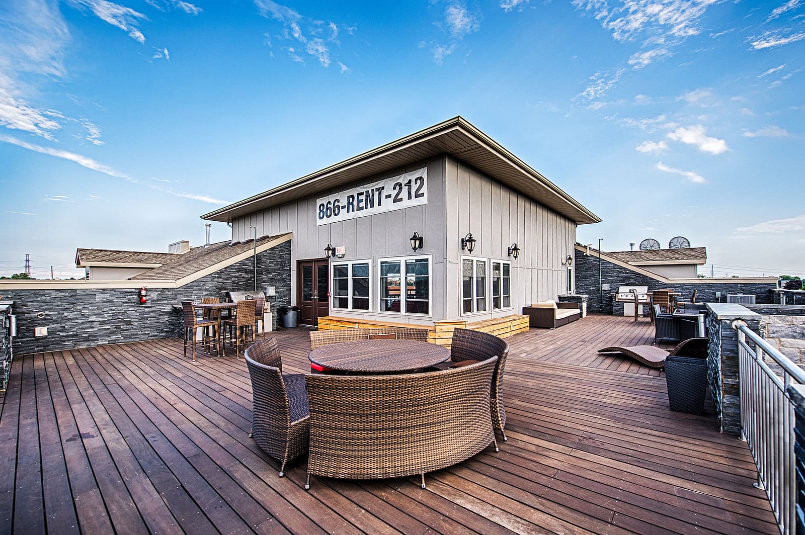 Rooftop terrace with barbeques, dining tables and lounge seating on the timber deck
