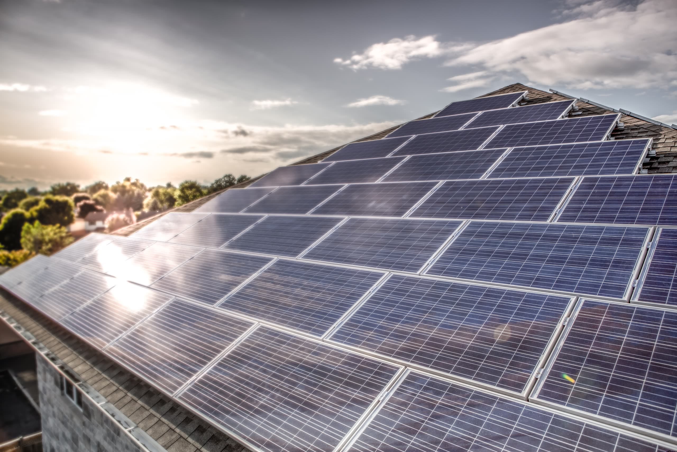 Solar panels covering Stonecrest's roof sections at sunset