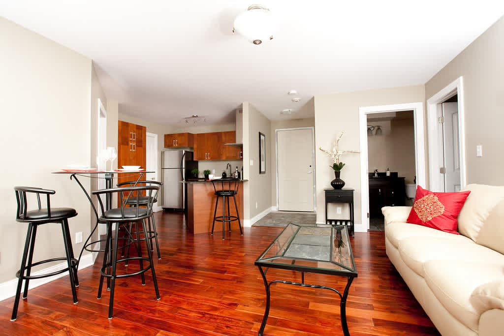 Open living and dining area with hardwood floors, looking through to the kitchen