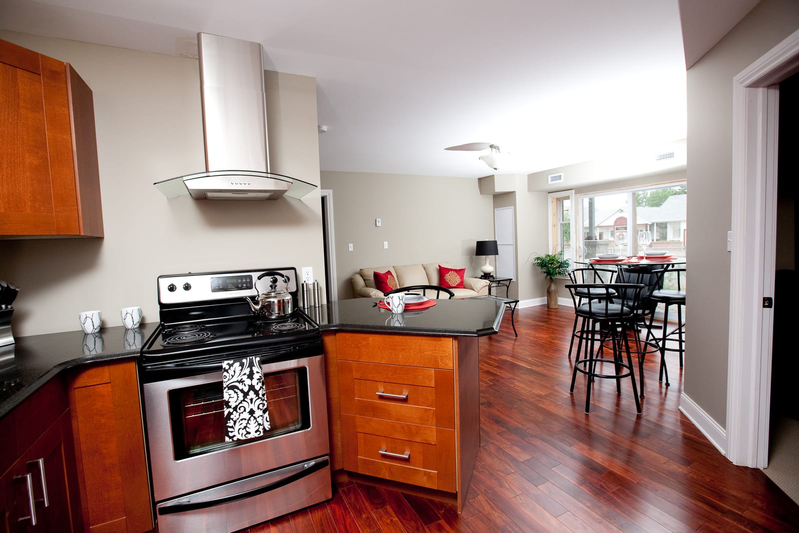 Kitchen with a stainless range and chimney hood, open to the dining and living area