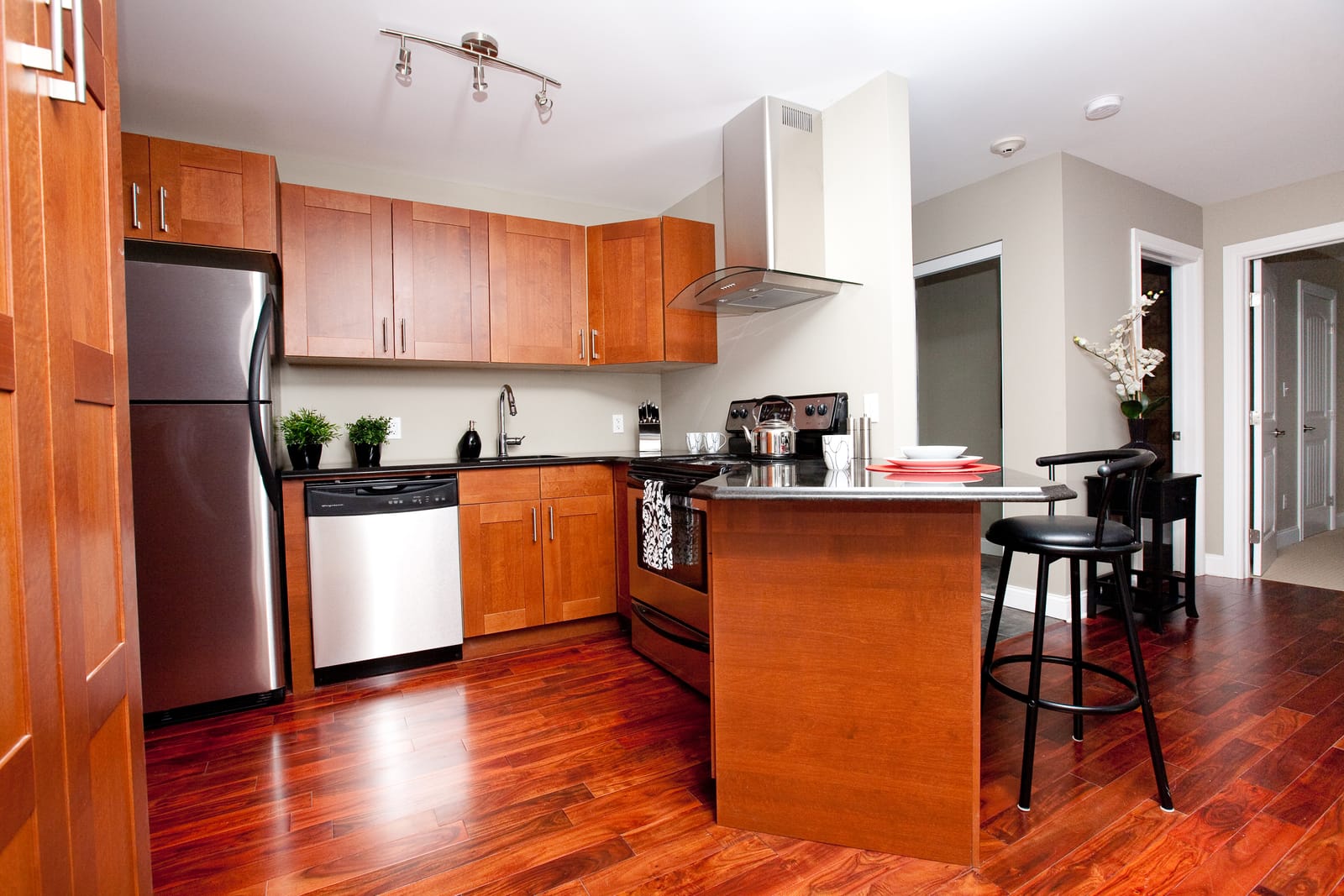 Kitchen with a granite breakfast bar, wood cabinetry and stainless steel appliances