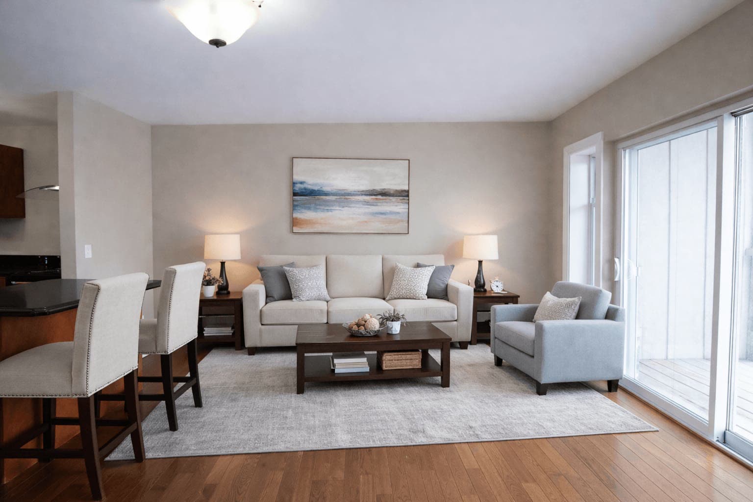 Living room with hardwood floors, seating and a breakfast bar off the kitchen