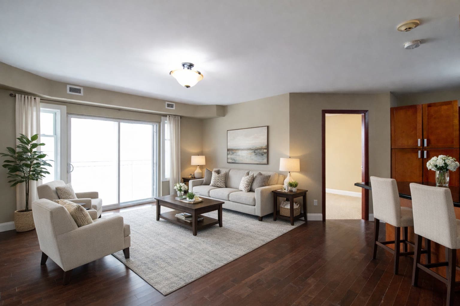 Suite living room with hardwood floors and a sliding door onto the balcony